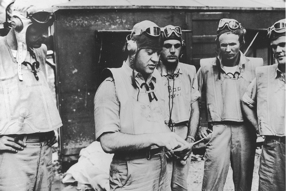 Boyington—known as "Pappy" or "Gramps" to his men—discusses tactics with VMF-214 members at Turtle Bay, Australia, in early September 1943. From left: Rolland N. Rinabarger, Henry M. Bourgeois, John R. Bergert and Stanley R. Bailey. (National Archives)