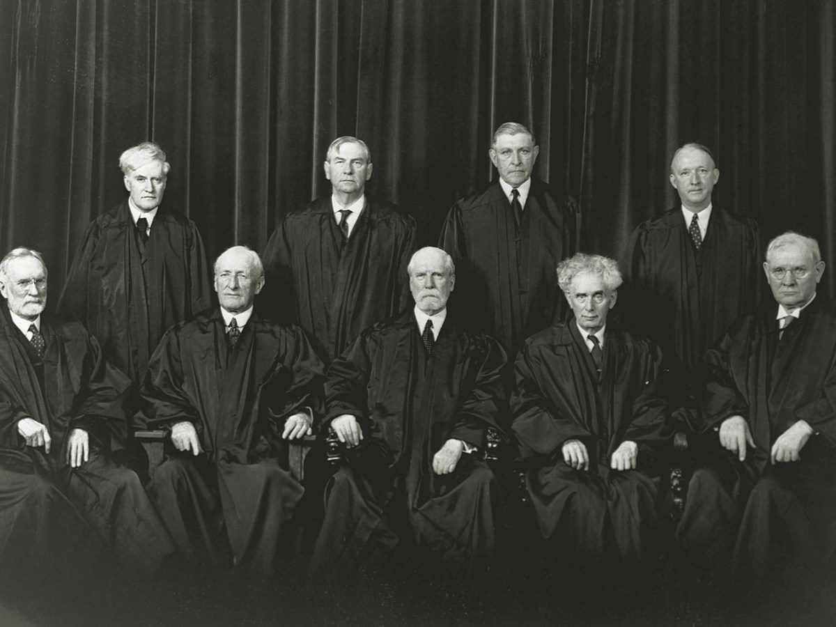 The justices of the Supreme Court. Sitting, from left to right, Justices Sutherland and McReynolds, Chief Justice Hughes, Justices Brandeis and Butler. Standing, left to right, Justices Cardozo, Stone, Roberts, and Black.