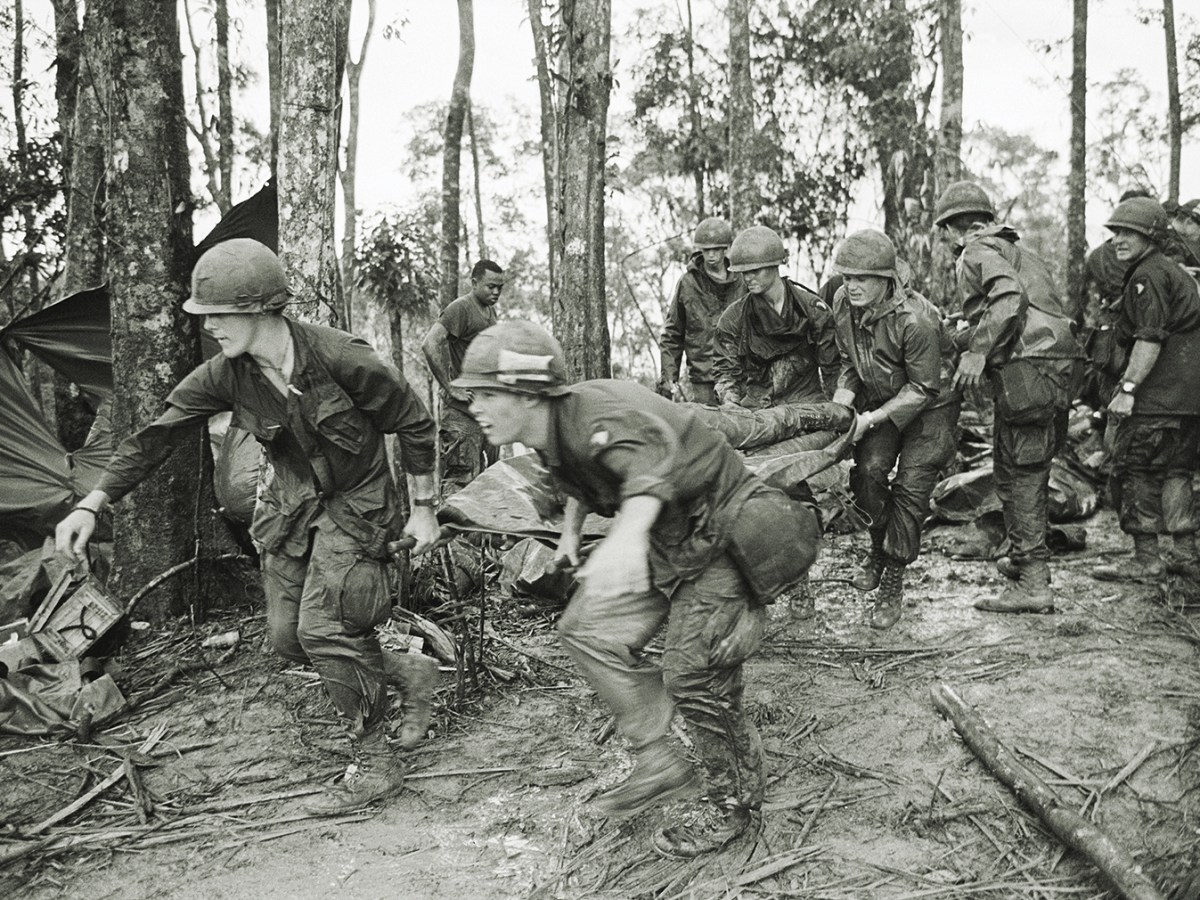 5/18/1969-A Shau Valley, South Vietnam: A quartet of U.S. 101st Air Division troopers keep low as they rush a stretcher-borne wounded comrade to a medical aid station during the battle for Hamburger Hill. New fighting erupted about the controversial hill on May 23.