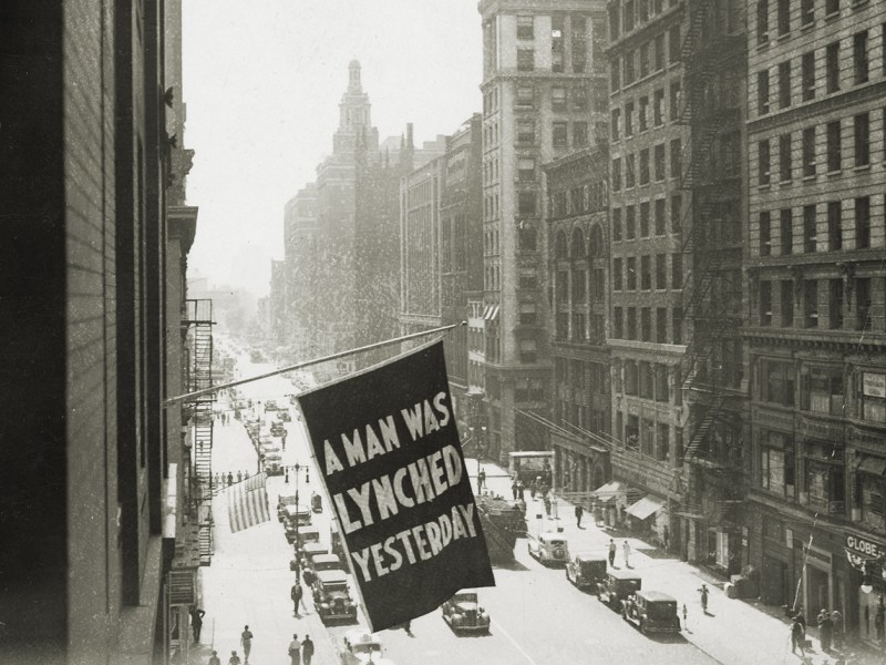 Photo of a flag outside the NAACP office with "A Man Was Lynched Yesterday" on it.