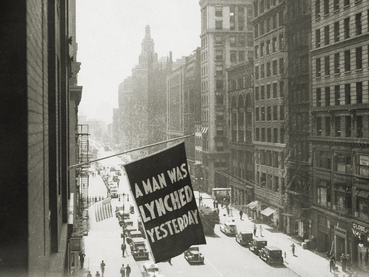Photo of a flag outside the NAACP office with "A Man Was Lynched Yesterday" on it.