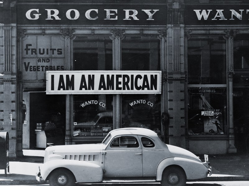Photo of Store front with "I am an American" sign in window