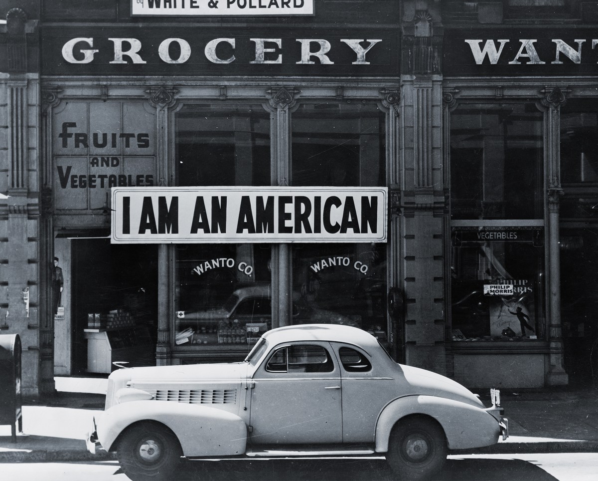 Photo of Store front with "I am an American" sign in window