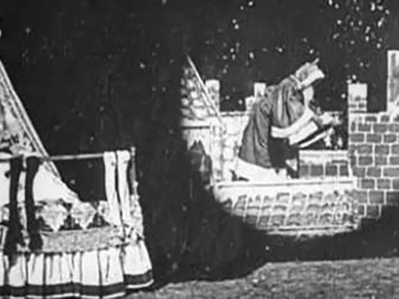 Santa prepares to descend a chimney in this still from Santa Claus (1898).