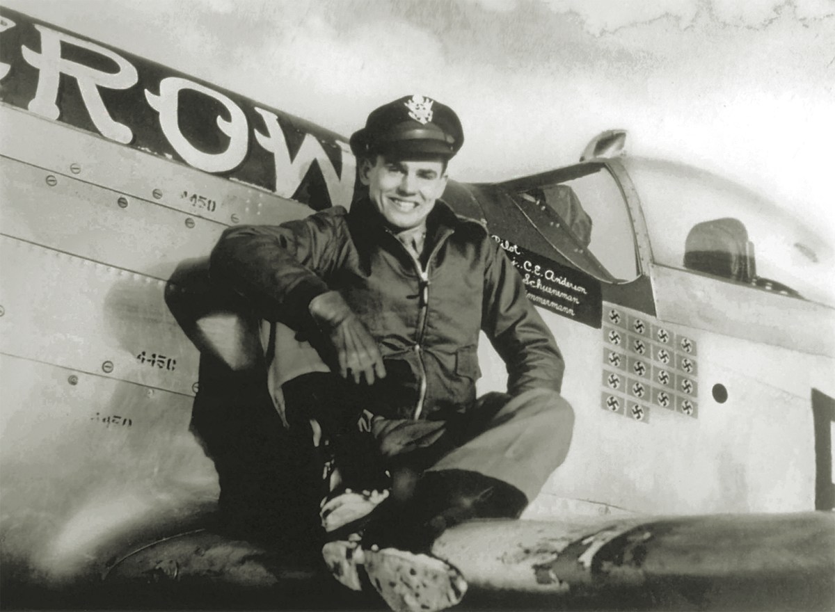 Photo of Major Bud Anderson poses in 1944 on the wing of his P-51D Mustang Old Crow, the victory markings beneath its canopy reflecting his status as a triple ace.