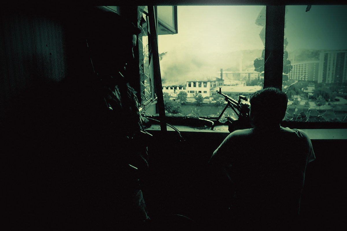 Photo of a sniper scaning for a target on the streets of embattled Sarajevo at the outset of the 1992–95 Bosnian War. The breakup of Yugoslavia was accompanied by ethnic strife, urban warfare and civilian displacement.