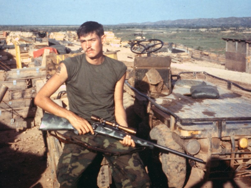 Photo of Chuck Mawhinney beside a pack mule.