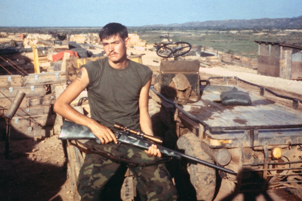 Photo of Chuck Mawhinney beside a pack mule.