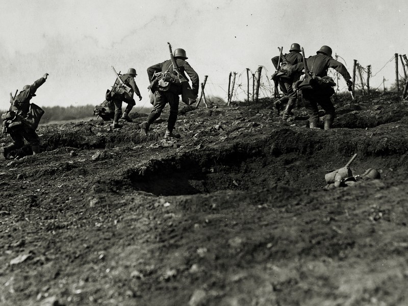Photo of German storm troops laden with equipment have to advance over open but broken ground. The enemy know of their approach because of a preliminary barrage.