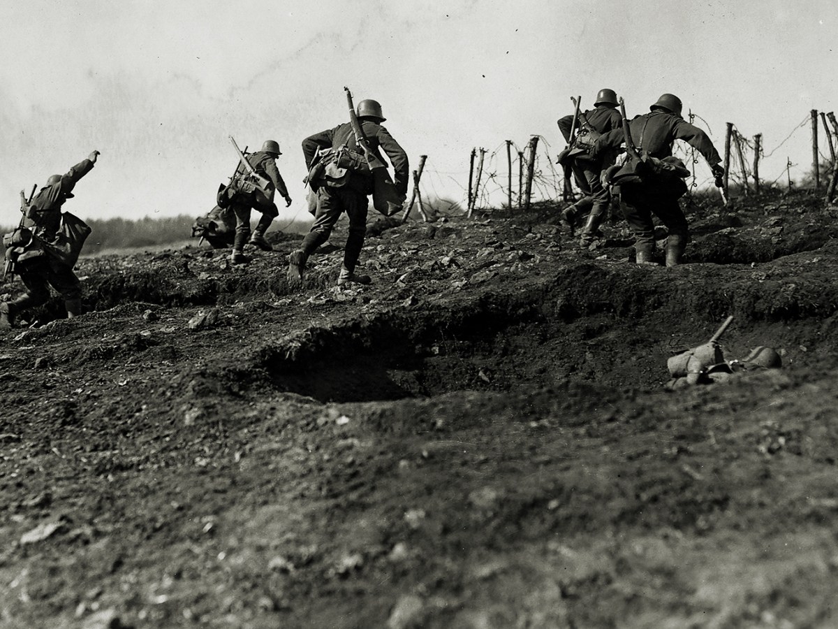 Photo of German storm troops laden with equipment have to advance over open but broken ground. The enemy know of their approach because of a preliminary barrage.