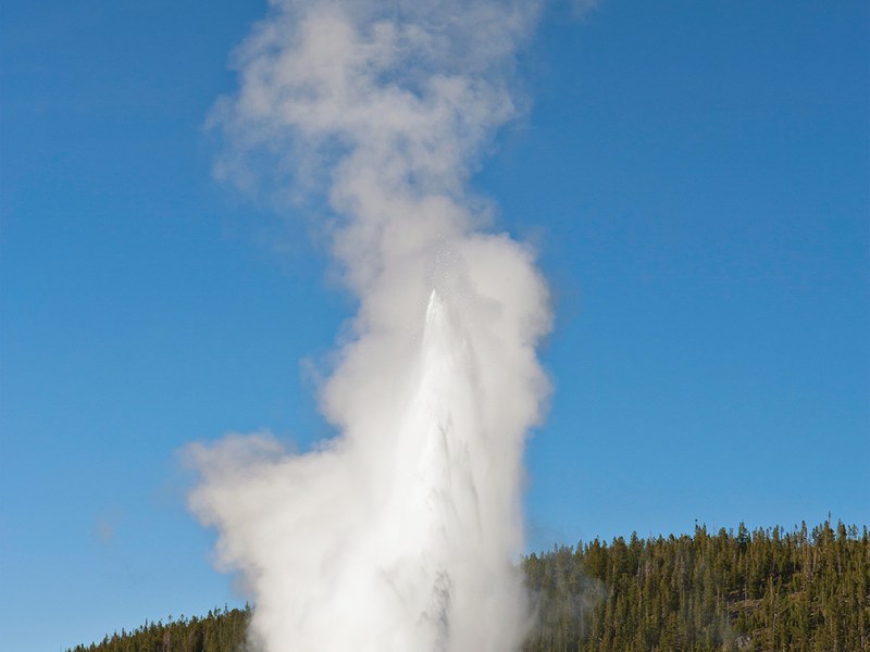 Photo of tourists watching Old Faithful, Yellowstone National Park.