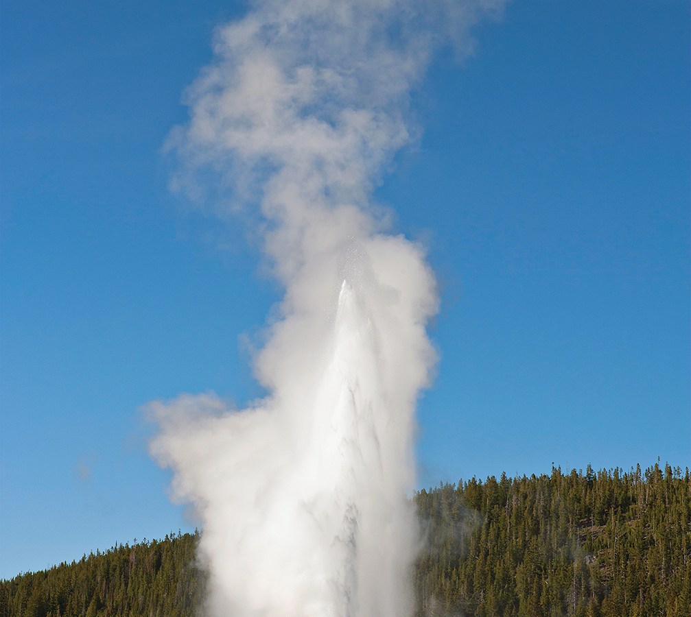 Photo of tourists watching Old Faithful, Yellowstone National Park.