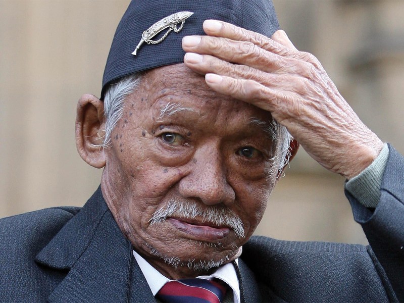 Photo of Honorary Sergeant Lachiman Gurung outside the Houses of Parliament in London.
