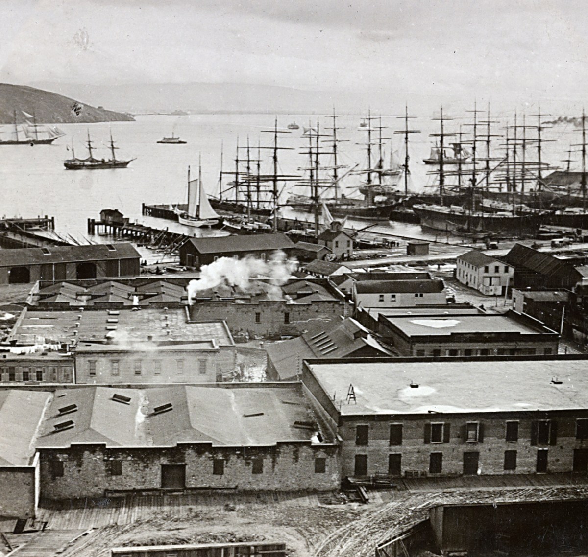 Photo of a crowded harbor scene with buildings and ships docked in slips or sailing around the harbor. San Francisco harbor from Telegraph Hill, Calif.